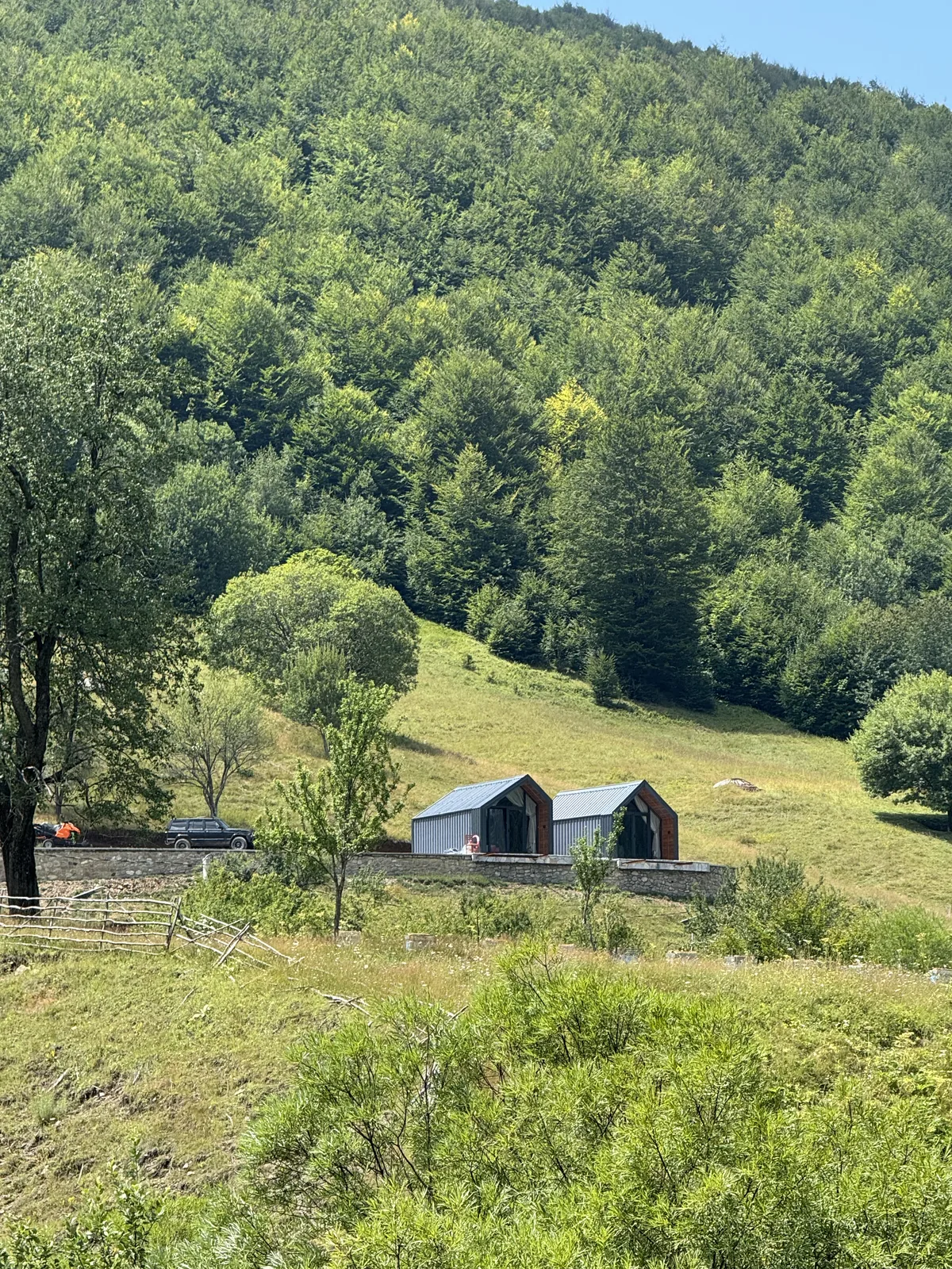 Dy Vilat Panoramike në livadh, me malin prapa